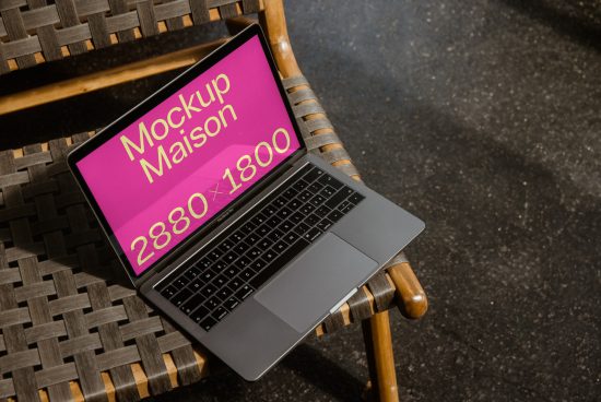 Laptop mockup on a wicker chair displaying screen for branding, digital design asset for creative professionals, versatile graphic template.