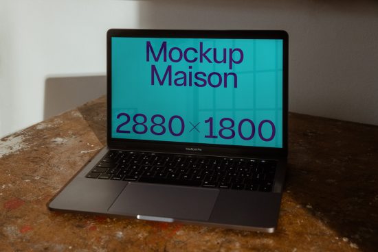 Laptop screen with Mockup Maison graphic, designers' asset, showcasing template resolution on a rustic table, essential mockup for presentations.
