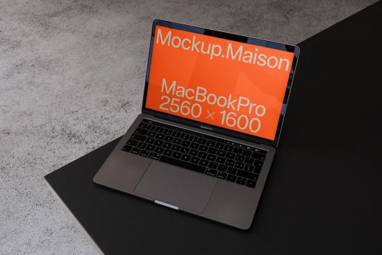 Laptop mockup on gray surface with screen displaying dimensions, useful for designers to showcase web and app designs.