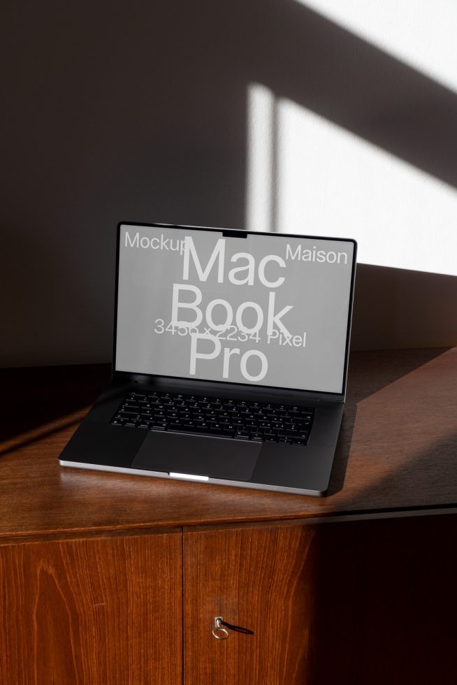 Laptop on desk mockup with play of light and shadow, realistic setting for digital product presentation, perfect for designers and creatives.