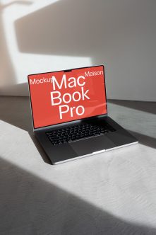 MacBook Pro on gray surface with red screen showing white text