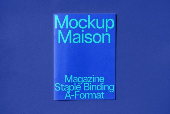 Blue magazine mockup with cyan text for design presentation, showcasing staple binding on a textured background, ideal for mockups category.