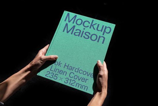 Hands holding a green book mockup titled Mockup Maison against a dark background, highlighting design and dimensions for presentation.