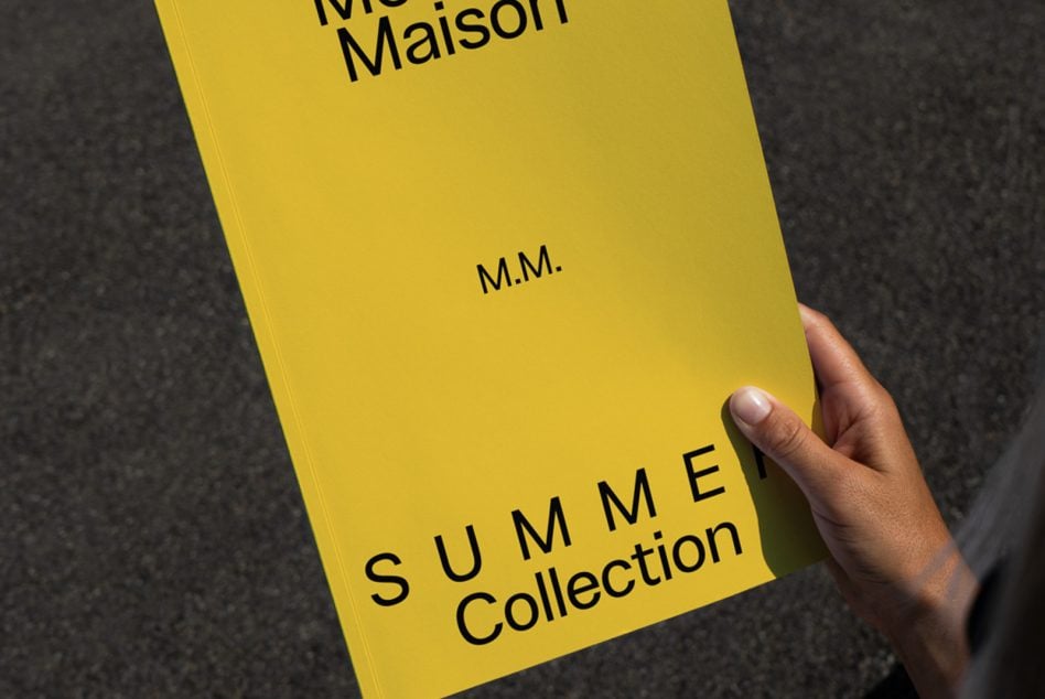 Yellow hardcover book with black typography held in hand indoors