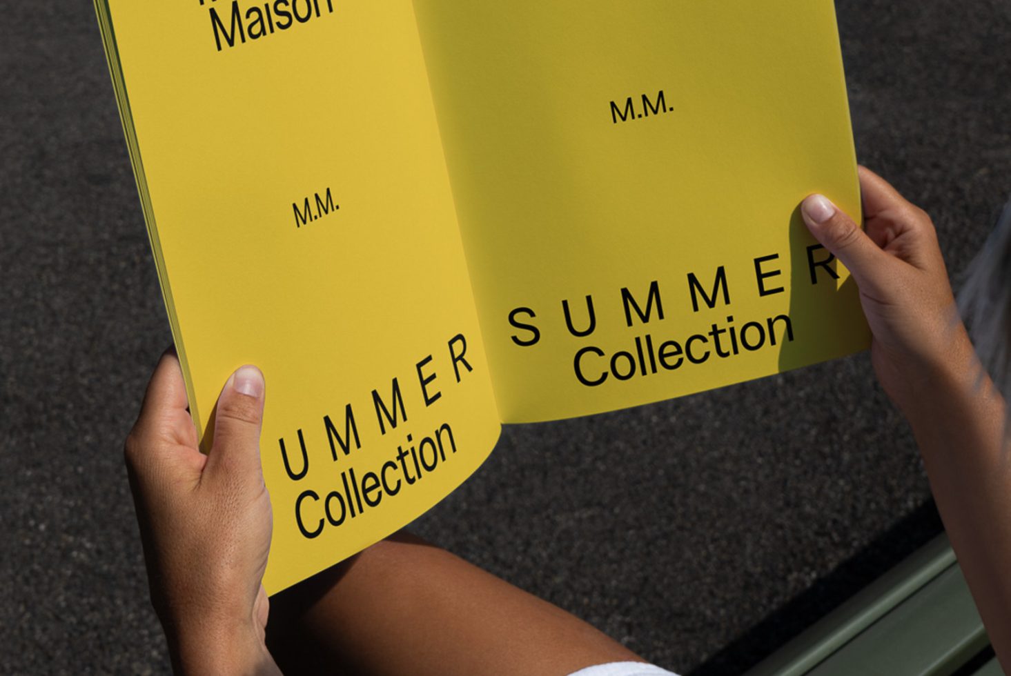 Close-up of hands holding a yellow pamphlet mockup with Summer Collection text, clear font, showcasing a design template for presentations.