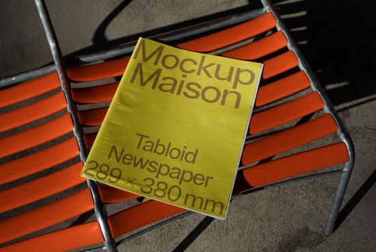 Yellow tabloid newspaper mockup on orange metal chair, urban shadow, realistic outdoor presentation for design, print template.