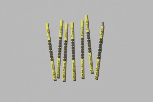 Yellow pencils with branded graphics floating on a gray background, ideal for stationery mockups, design assets, realistic templates.