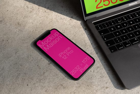Smartphone digital mockup beside laptop on concrete surface, ideal for showcasing design apps and responsive websites for designers.