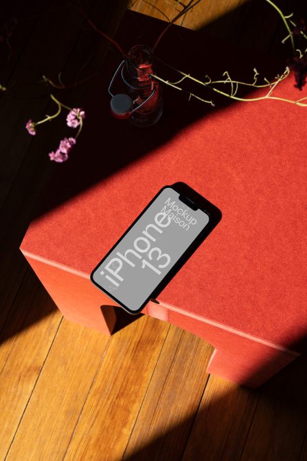 iPhone 13 mockup on orange box with light gray screen variant