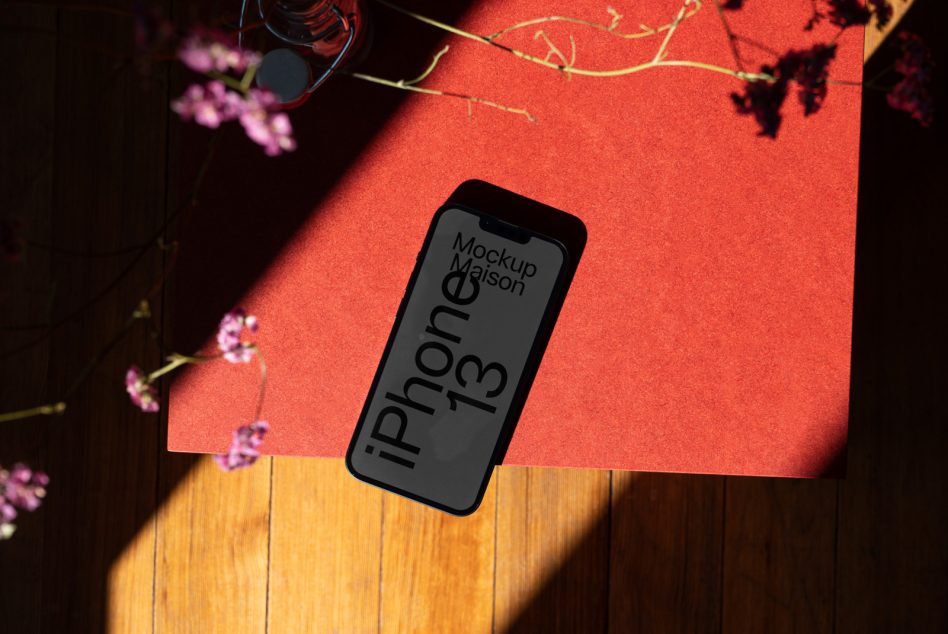 iPhone 13 mockup on red textured paper with natural shadows, ideal for app design presentation in mockups category for professional designers.