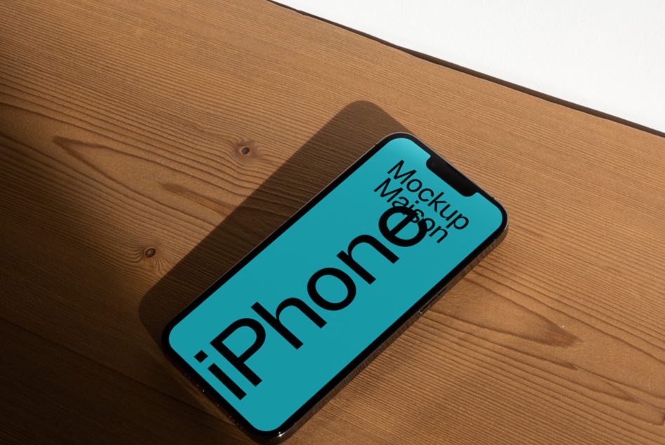 Realistic smartphone mockup on wooden surface for app design presentation. High-quality iPhone template for graphic display.