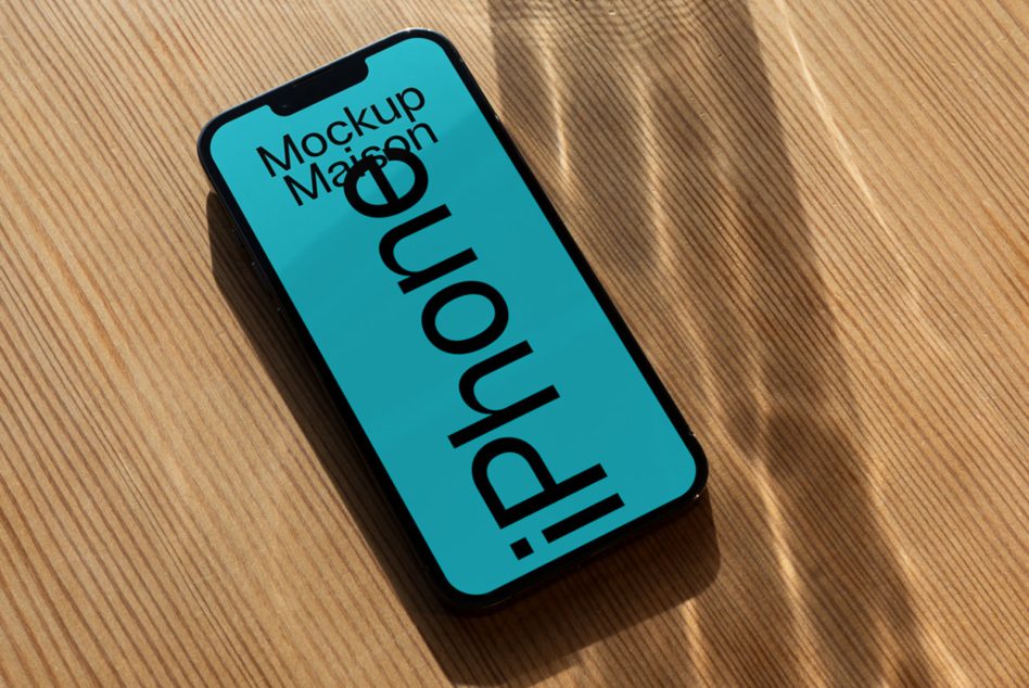 Teal iPhone mockup on bright wood surface with soft natural light shadows