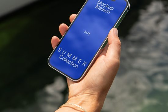 Hand holding smartphone displaying Mockup Maison's Summer Collection ad, ideal for designers seeking mobile mockups, clean visual presentation.