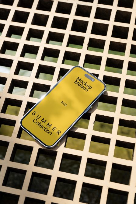 Smartphone mockup with yellow screen on lattice background for showcasing design templates, ideal for designers' summer collection presentations.