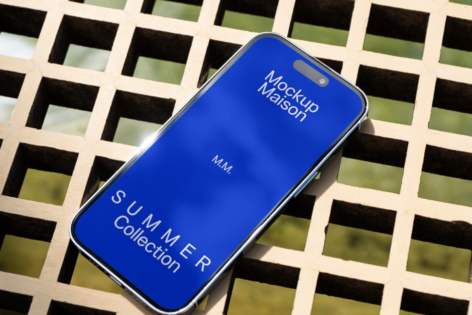 Smartphone mockup on lattice background with blue screen displaying design text, ideal for designers' summer collection presentations.