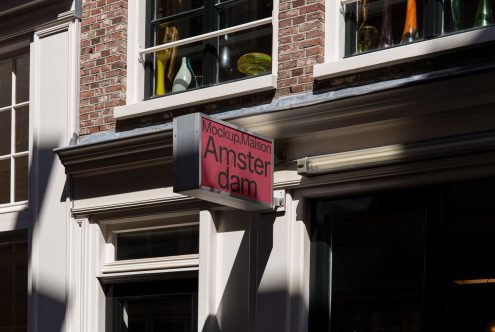 Urban shop sign mockup in sunlight showcasing bold typeface for potential use in design presentations and storefront mockups.