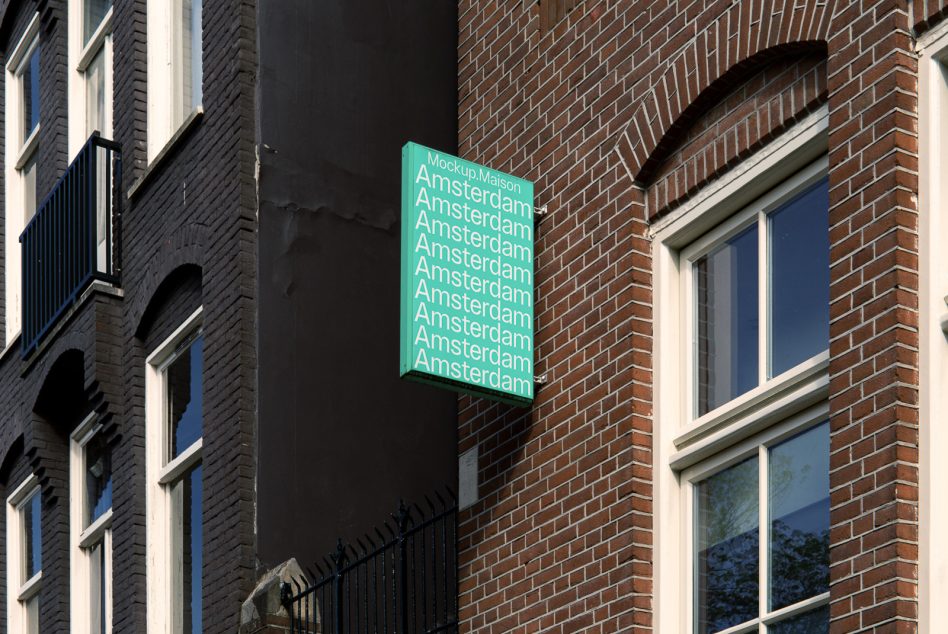 Bright green neon sign with repeating Amsterdam text mounted on brick building facade