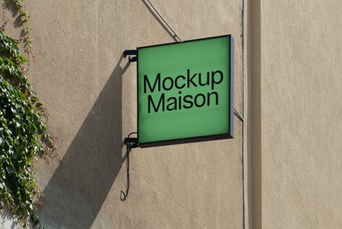 Square outdoor signboard mockup on wall with green background and shadow, ideal for store branding graphics display.