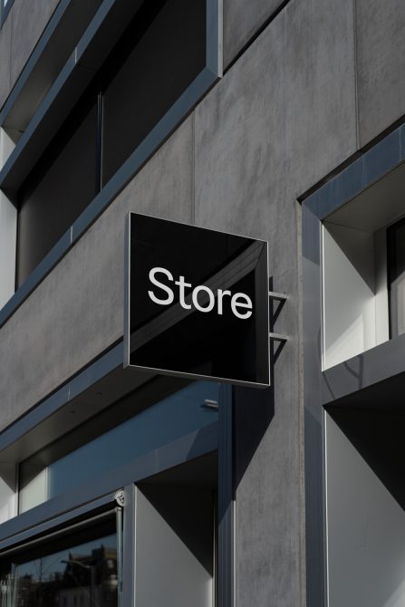 Modern storefront sign mockup on a sleek building facade with minimalistic design elements, perfect for branding and logo presentations.