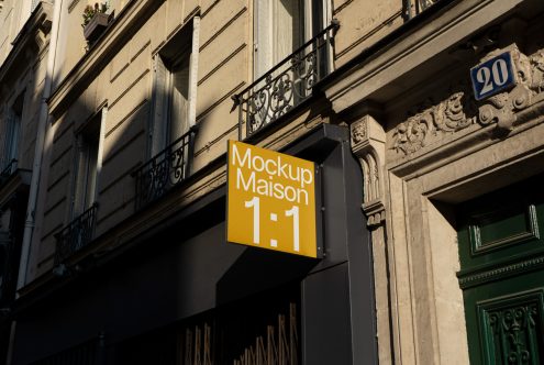 Street-level sign mockup in urban setting for storefront branding display with clear sky and building facade, ideal for designers.