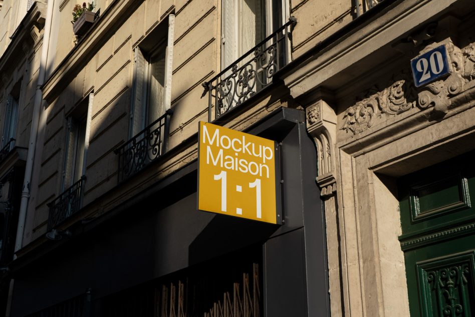Golden yellow glowing sign mounted on black metal support outside classic stone building