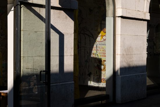 Urban storefront with intriguing shadows and graffiti, ideal for mockup background or texture overlay in design projects.