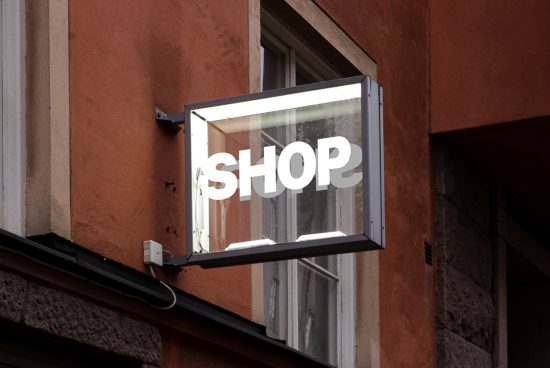 Storefront sign mockup with the word SHOP in bold letters, suitable for branding, set against an urban building background.
