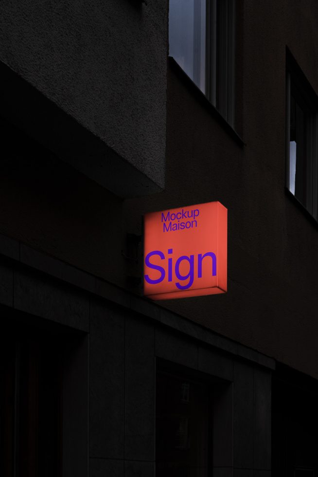 Editable outdoor wall-mounted sign mockup in dim light, displaying a customizable shopfront logo for realistic branding presentation.