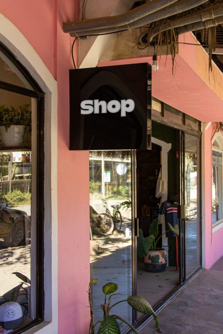 Storefront shop sign mockup hanging on a business entrance, clear typography, urban setting, ideal for branding presentation.