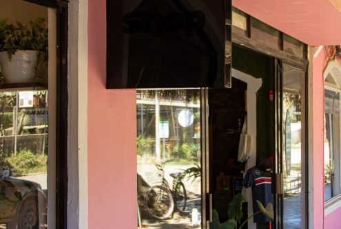 Storefront glass door mockup with reflective surface, vibrant urban setting, ideal for logo and signage designs for retail businesses.