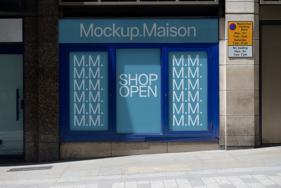 Shop window with blue frame displaying teal panels with M.M. pattern, center text says Shop Open
