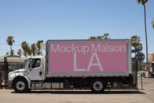 Delivery truck with mockup advertising space on pink background parked in urban setting, suitable for designers to showcase branding projects.