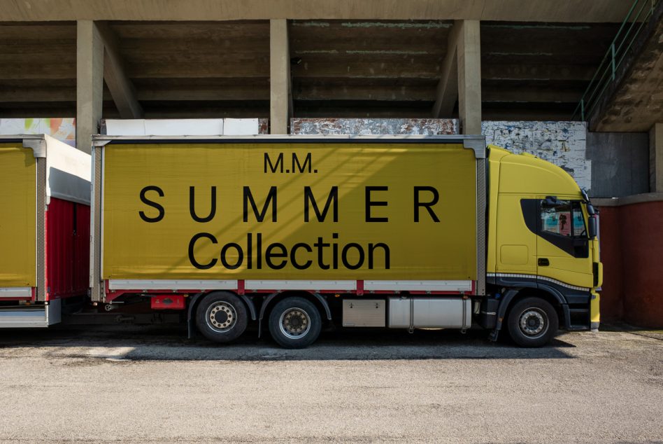 Yellow delivery truck with bold Summer Collection sign Mockup parked under bridge, ideal for showcasing branding and advertising designs.