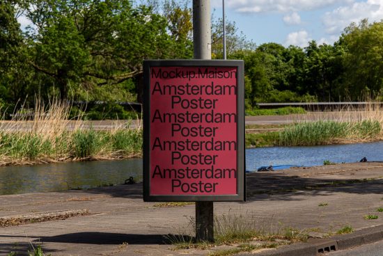 Outdoor poster mockup on a metal stand displaying repetitive text "Amsterdam Poster", surrounded by natural scenery, ideal for graphic designers.