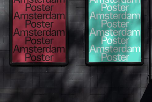 Two illuminated poster frames on a dark brick wall, one red, one cyan, with repeated text, ideal for mockup designs and templates.