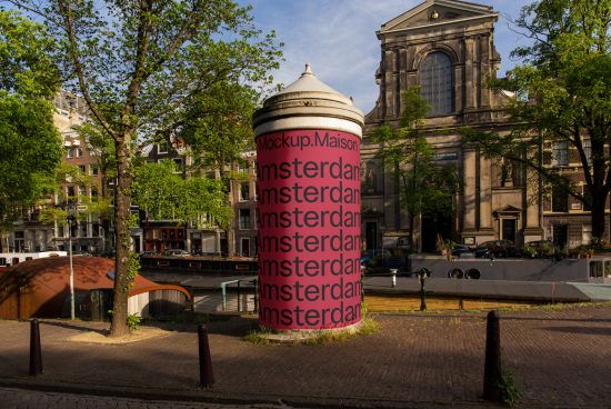 Urban mockup showcasing repeated font on a cylindrical building with greenery and historic architecture in the background. Ideal for designers looking for realistic urban mockup templates.