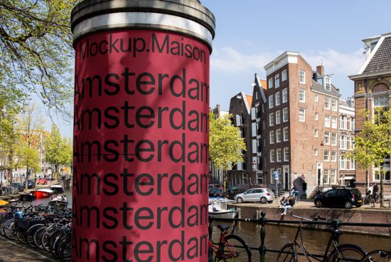 Amsterdam street view with mockup advertising column, canal, bicycles, trees, and typical Dutch houses, perfect for urban mockup graphics.