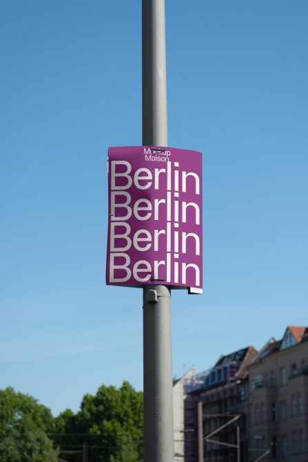 Magenta pole banner with Berlin text in white letters against blue sky