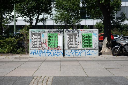 Urban street scene featuring mockup billboards with repeat Berlin text overlaid, graffiti, trees, motorcycle, and a sleek car.