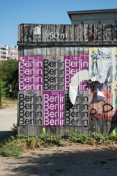 Urban textured wall with layered Berlin posters in various fonts, suitable for mockups or graphic design inspiration.