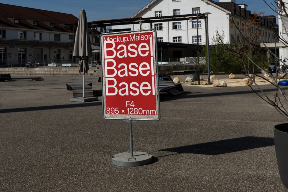 Red poster mockup on stand in courtyard with Basel text repeating three times