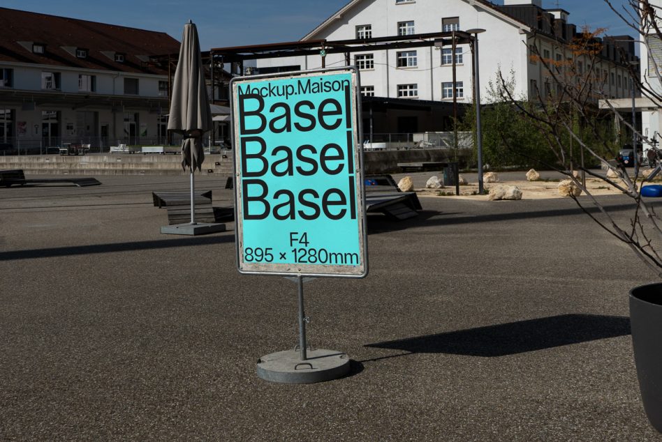 Turquoise plaza sign on concrete base with Basel text, urban European setting