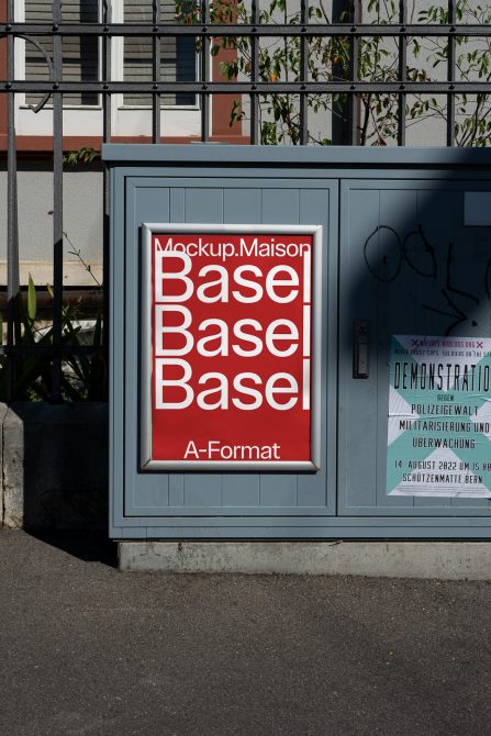 Red A-Format poster mockup in aluminum frame on gray storefront door