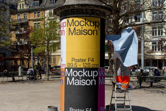 Urban advertising column mockup in a lively outdoor setting with a person applying a poster, ideal for realistic advertising presentations.