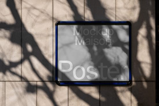Wall-mounted poster mockup in sunlight with tree shadows, perfect for designers to showcase advertising and branding designs.