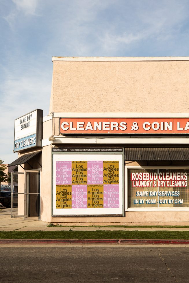 Vintage urban dry cleaner storefront with clear blue sky, ideal for mockup designs, cityscape graphics, and storefront template assets.