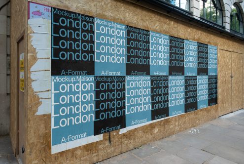 Plywood construction barrier featuring layered street posters with repetitive Mockup Maison and London text, urban, worn graphic design look.