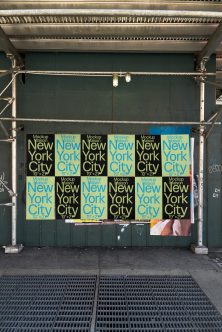Grid of twelve small posters on dark garage door, alternating lime, blue, yellow colors