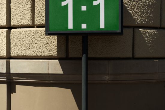 Green street sign with '1:1' text mockup on building wall in sunlight, with shadow, ideal for design and font presentations.
