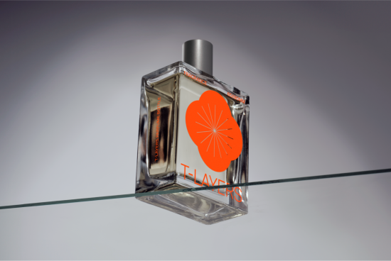 Perfume bottle mockup on glass surface with elegant branding for design presentation, featuring a clear container and orange label graphics.